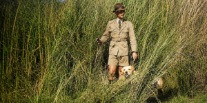 Man in long grass with dog